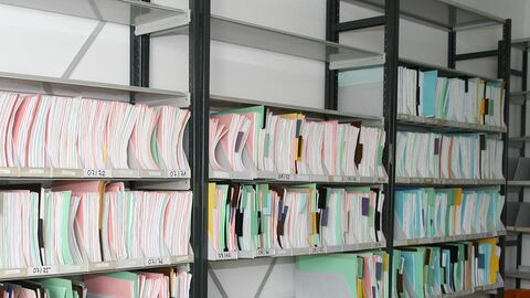 Regal mit Hängeordnern, einige Stellen leer.