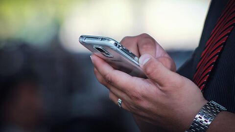 Kontakt Smartphone, auf dem ein Mann tippt.