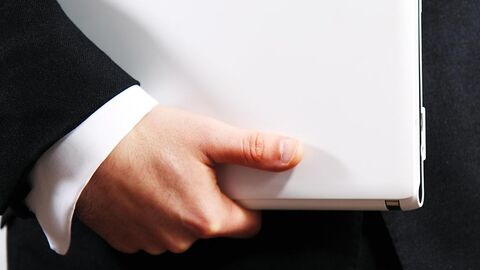 Hand hält einen weißen Ordner fest.