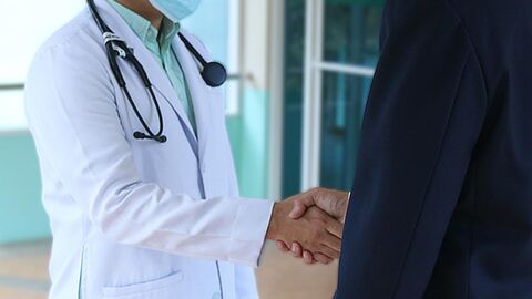 Arzt schüttelt einem Patienten die Hand.