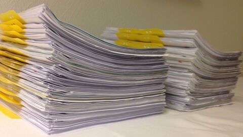 Zwei Stapel mit Vorgängen liegen auf einem weißen Untergrund.